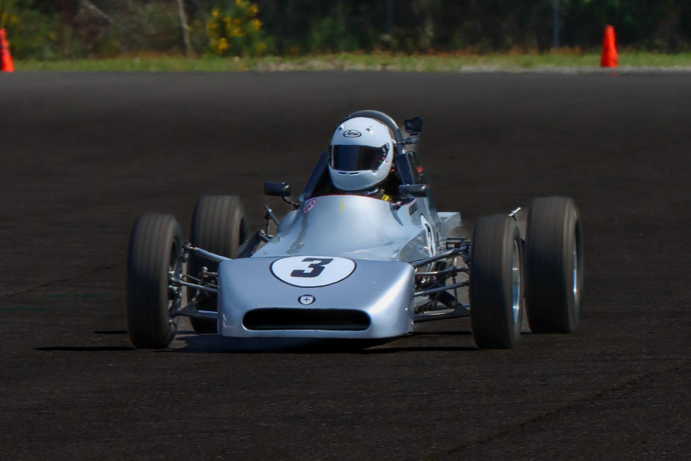 The number 3 Crosslé head-on, driver in a white Arai helmet